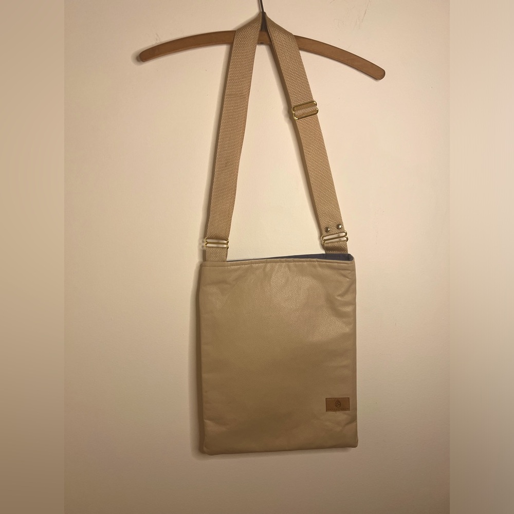 unshattered crossbody tote Tan with blue lining.